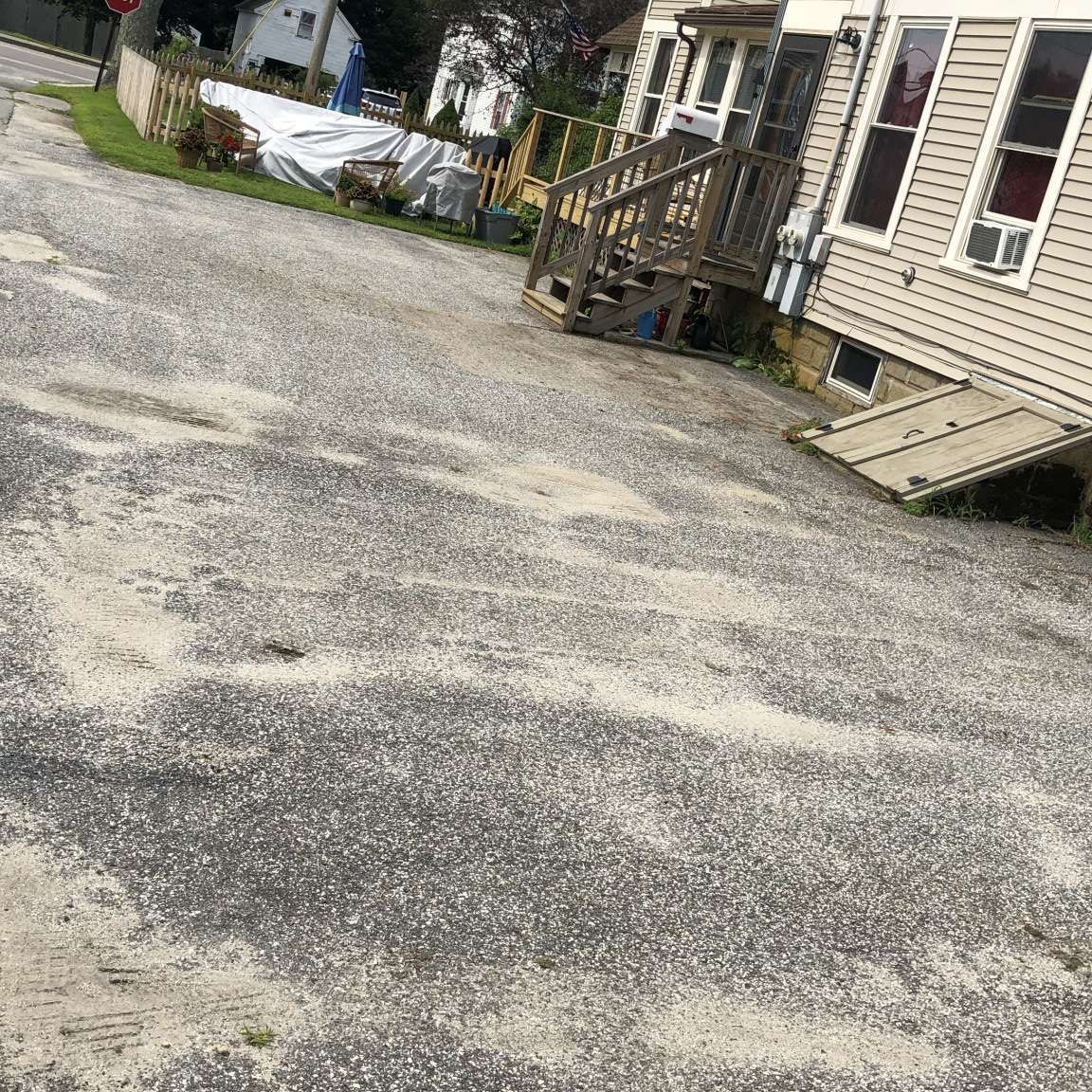 A gravel driveway leading to a house with a ramp.