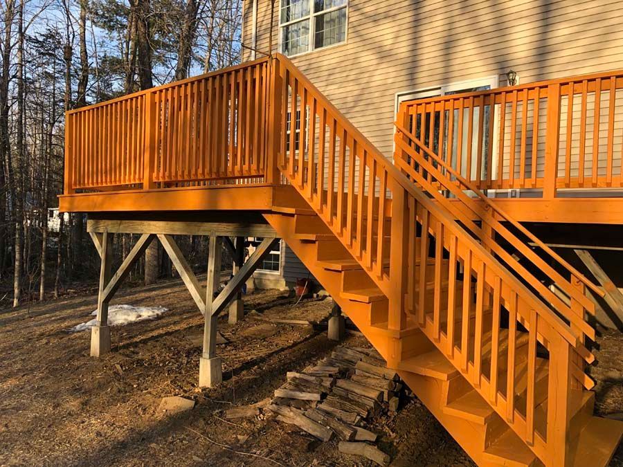 A wooden deck with orange stairs leading up to it.