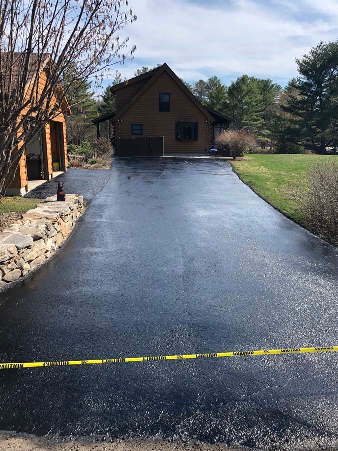 A driveway leading to a house with a yellow tape.