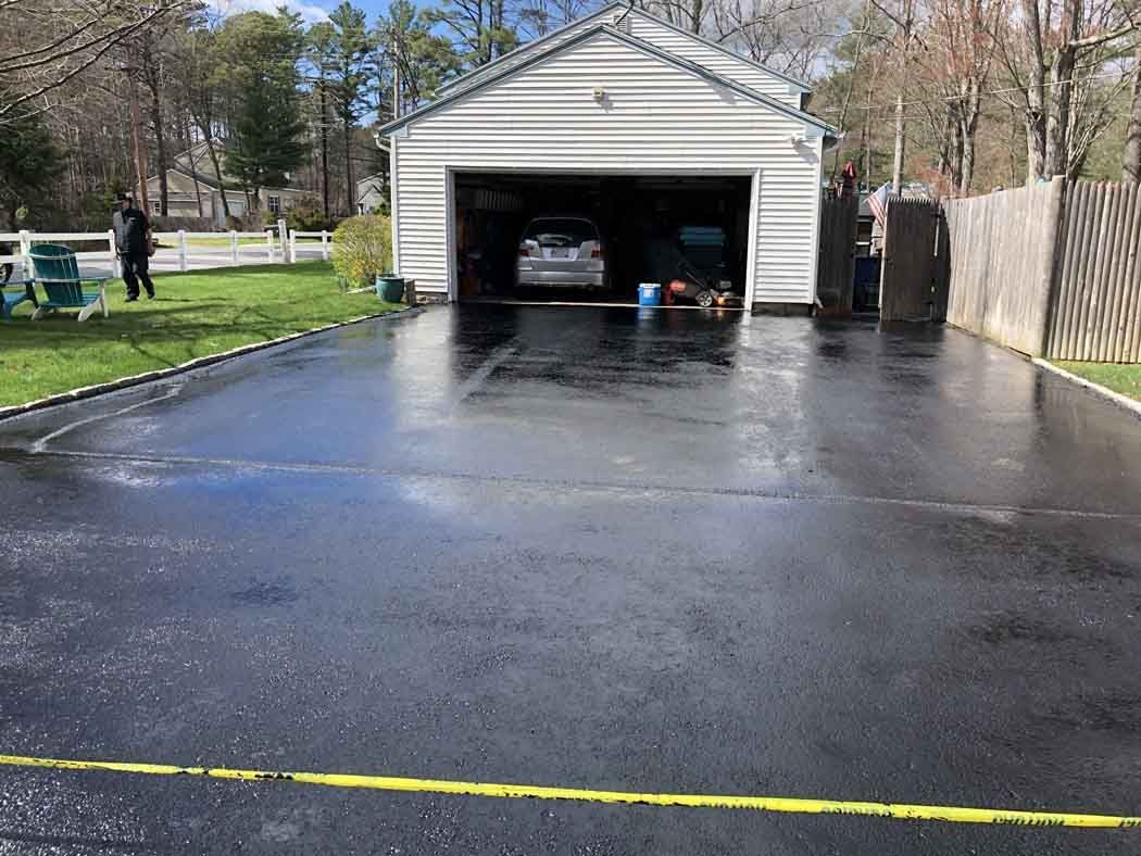 A car is parked in a garage next to a driveway.