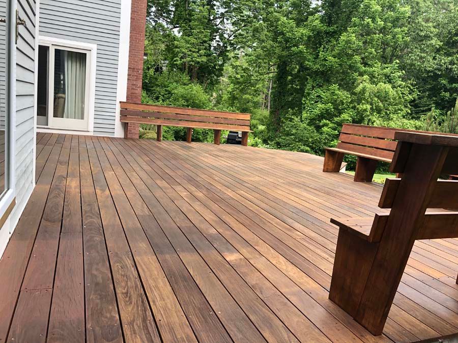 A wooden deck with a bench and a table on it.