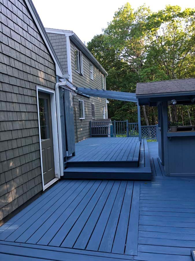 A house with a blue deck and stairs leading to it