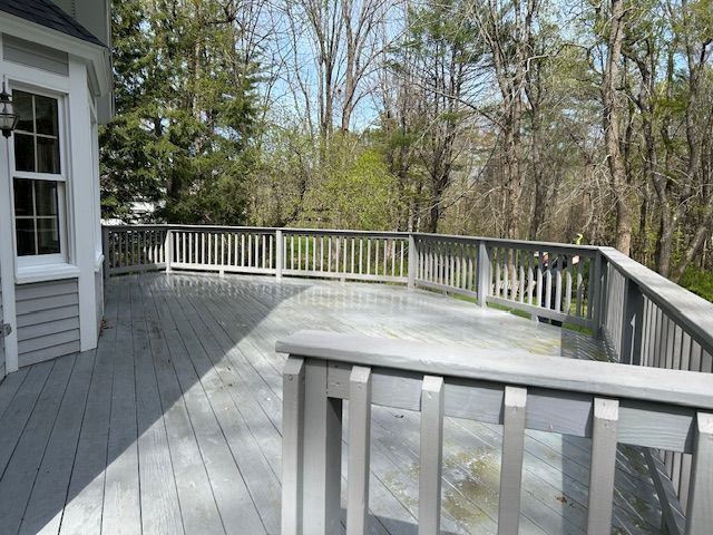 A green deck with a white railing and a bucket on it.