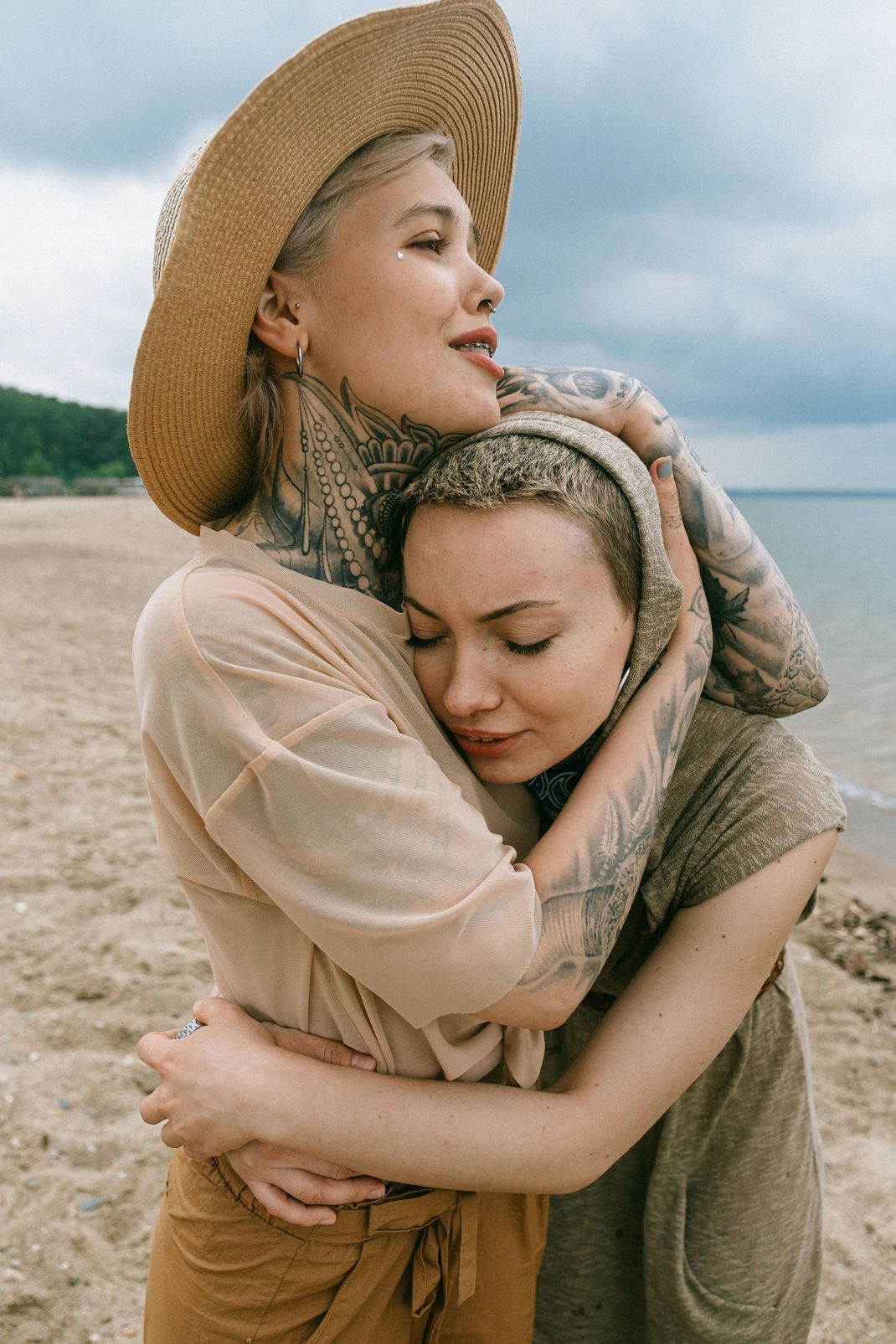 Two women are hugging each other on the beach.