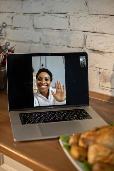 A laptop computer is open to a video call with a woman.