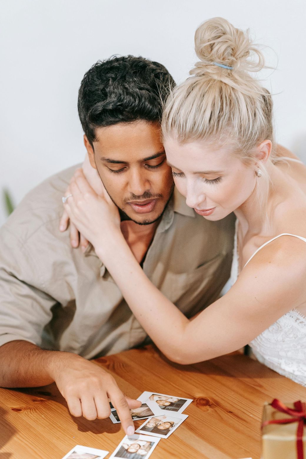 A man and a woman are sitting at a table looking at pictures.