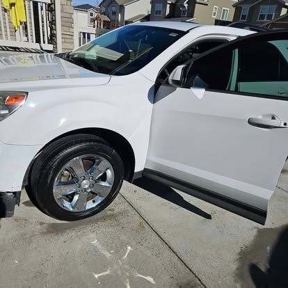 A white SUV parked on a driveway with its front passenger door open.