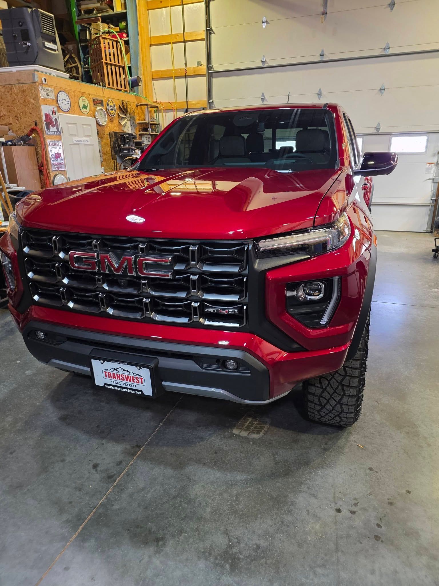 A red GMC Canyon truck parked inside a garage.