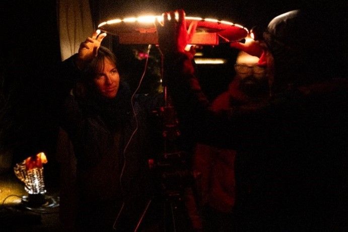 Person adjusting a light fixture under low light conditions, preparing for night sky observation.