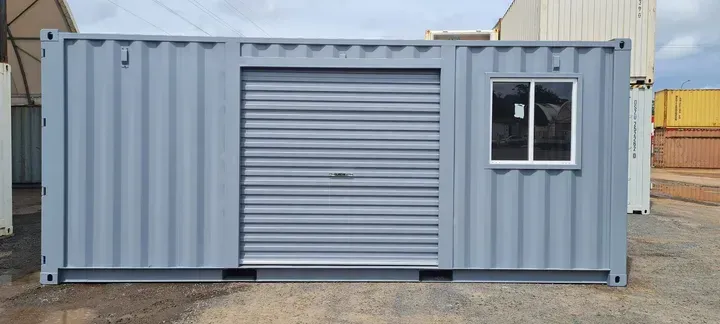 A shipping container with a garage door and a window.