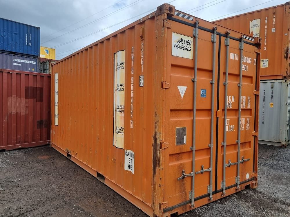 Orange Shipping Container With Visible Metal Locks and Labels