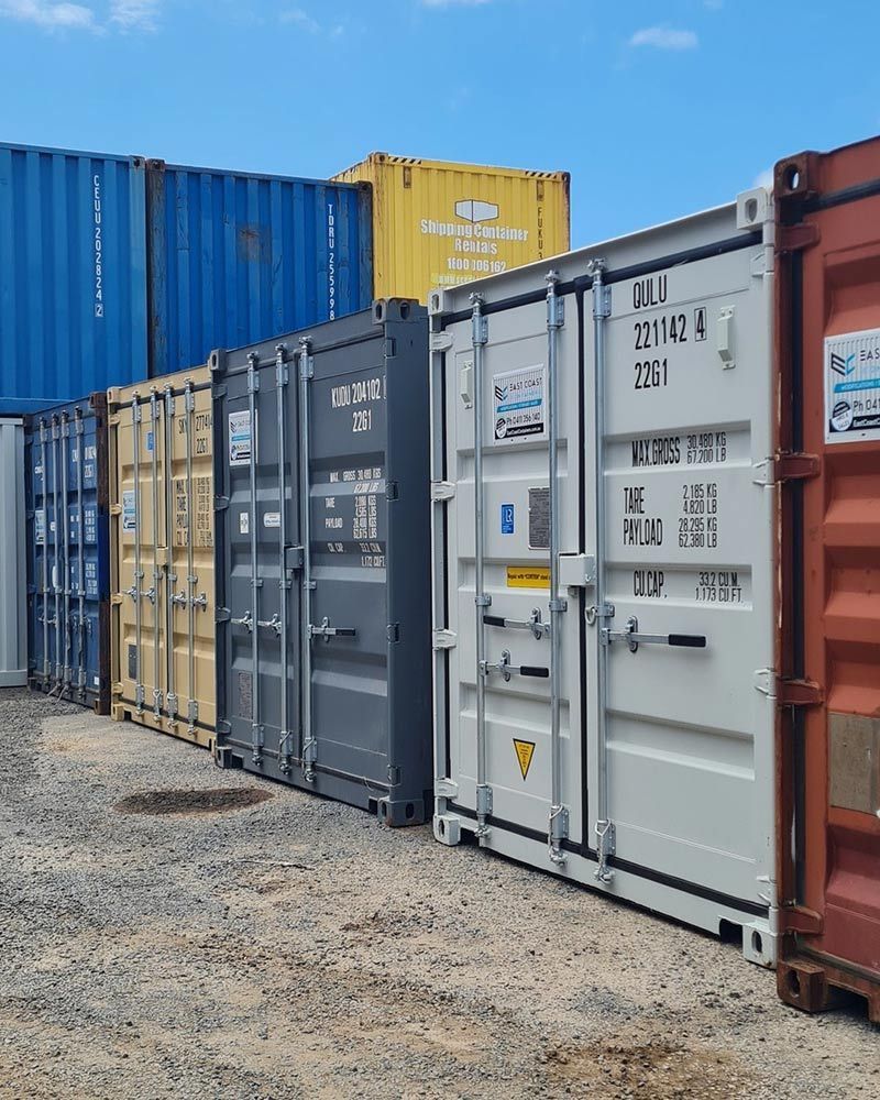 Row of Shipping Containers Lined Up in a Dirt Lot — East Coast Containers Shipping Containers and Transport in Gympie, QLD