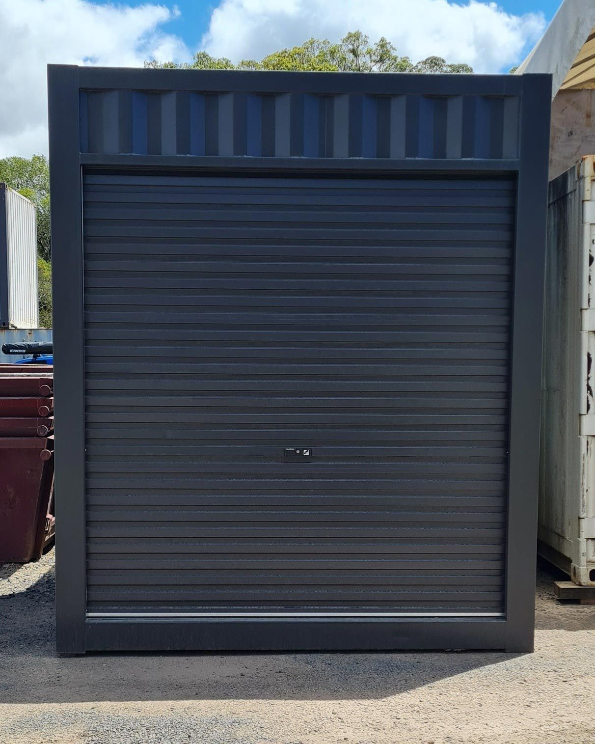 Black Container Garage Door on a Gravel Road — East Coast Containers Shipping Containers and Transport in Chevallum, QLD