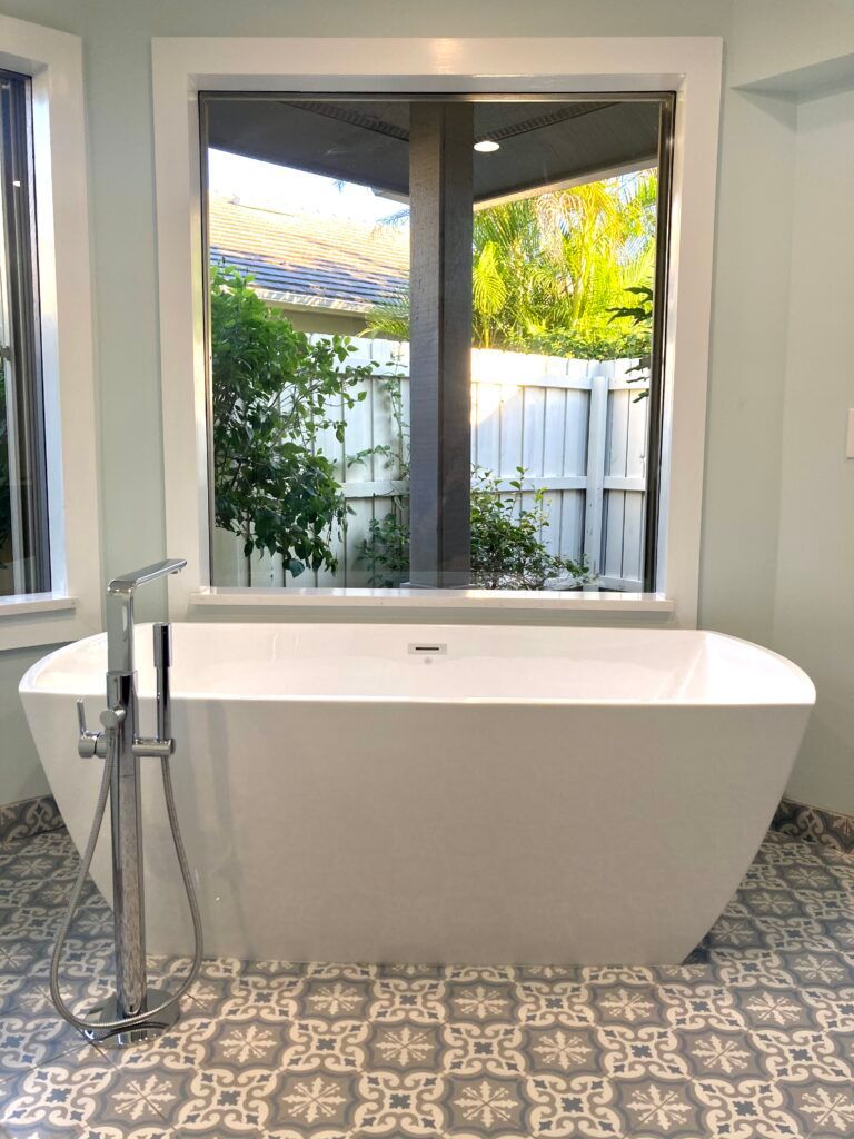 A bathroom with a bathtub and a window.