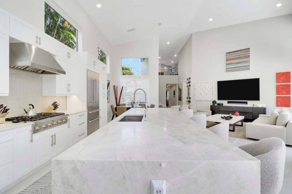 A kitchen with white cabinets and a large island in the middle