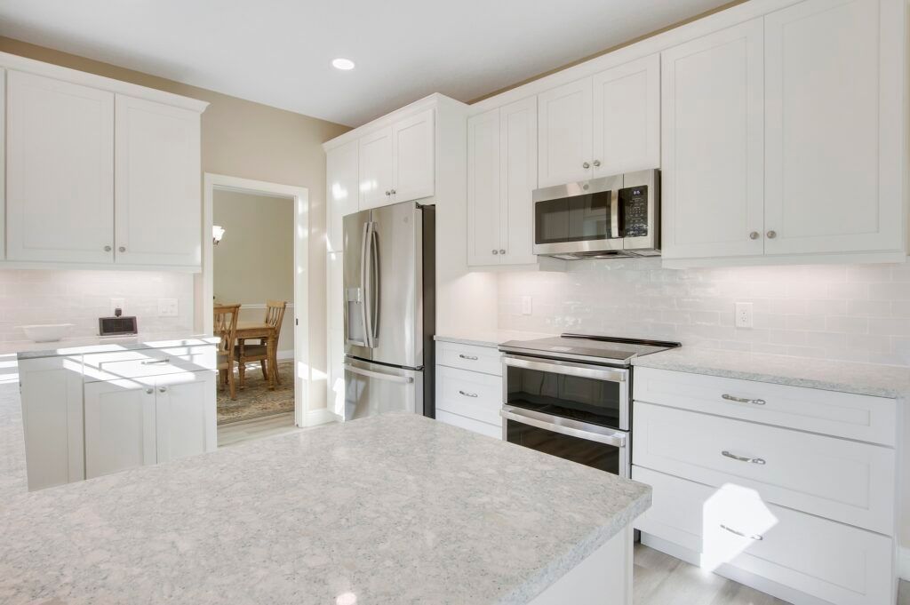 A kitchen with white cabinets and granite counter tops