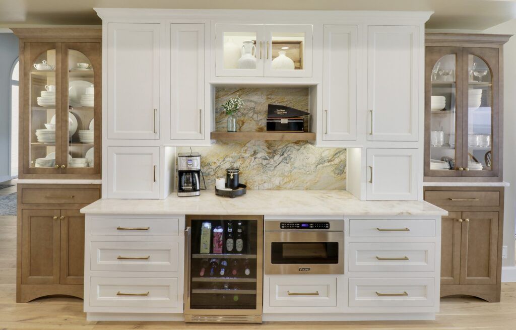 A kitchen with white cabinets and wooden cabinets and a wine cooler.