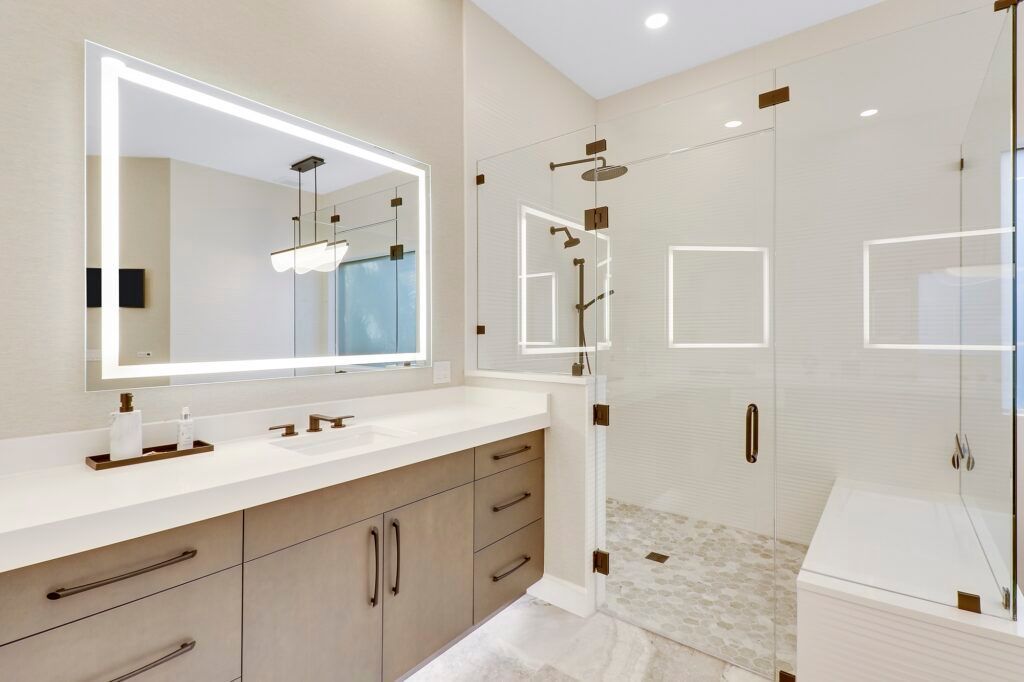 A bathroom with a large mirror and a walk in shower.