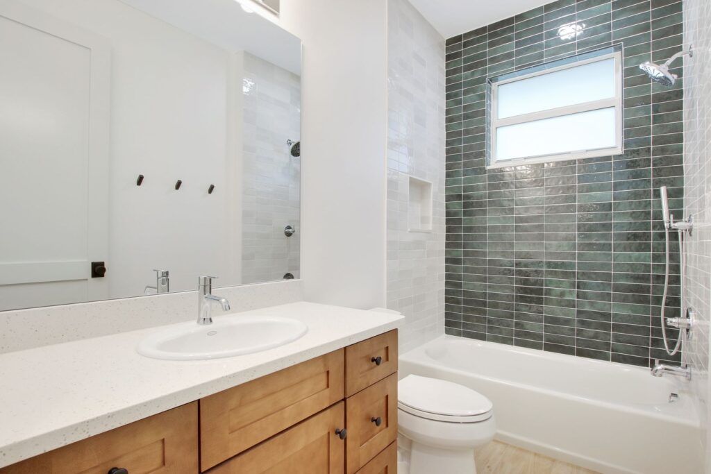 A bathroom with a sink , toilet , tub and mirror.