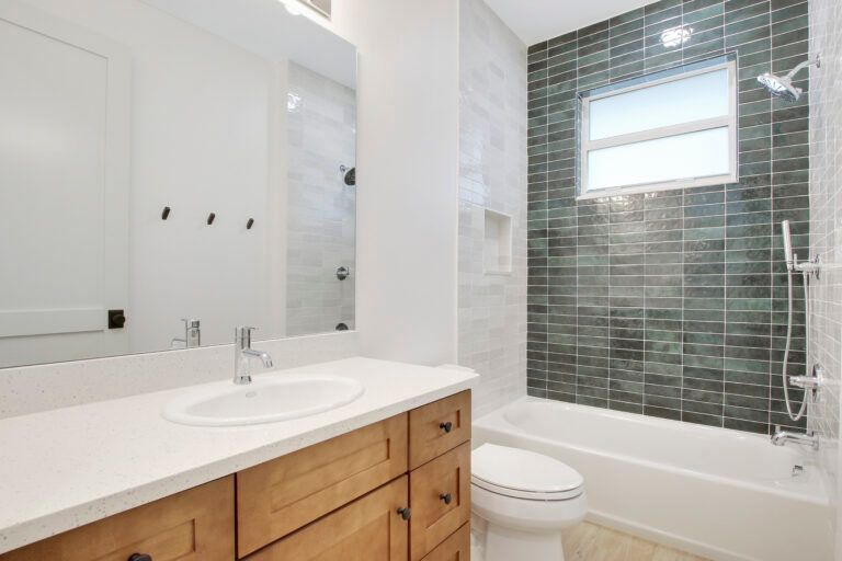 A bathroom with a sink , toilet , tub and mirror.
