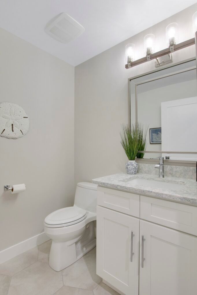 A bathroom with a toilet , sink and mirror.