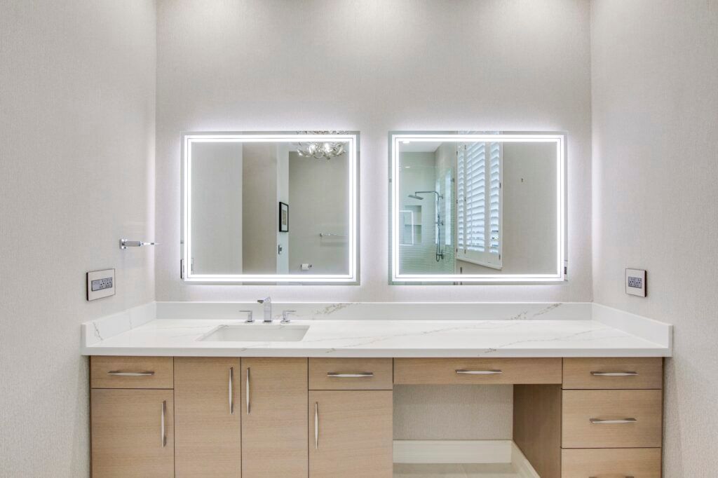 A bathroom with two mirrors and a sink.