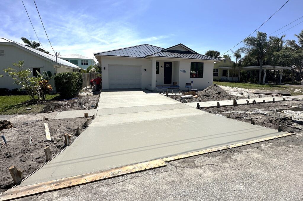 A concrete driveway is being built in front of a house.