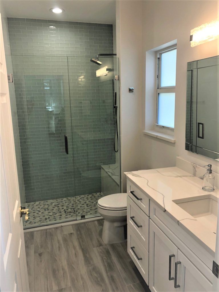 A bathroom with a toilet , sink , and walk in shower.