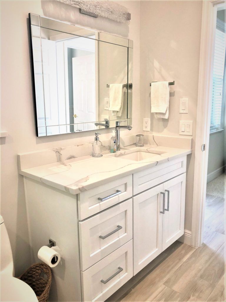 A bathroom with a sink , mirror and toilet.