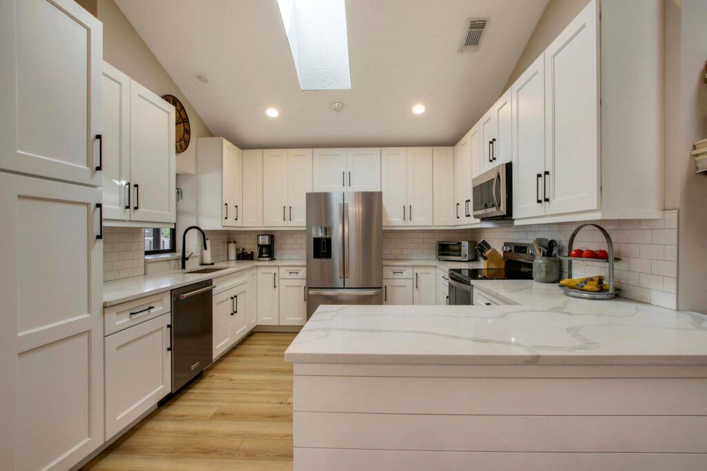 A kitchen with white cabinets and stainless steel appliances.