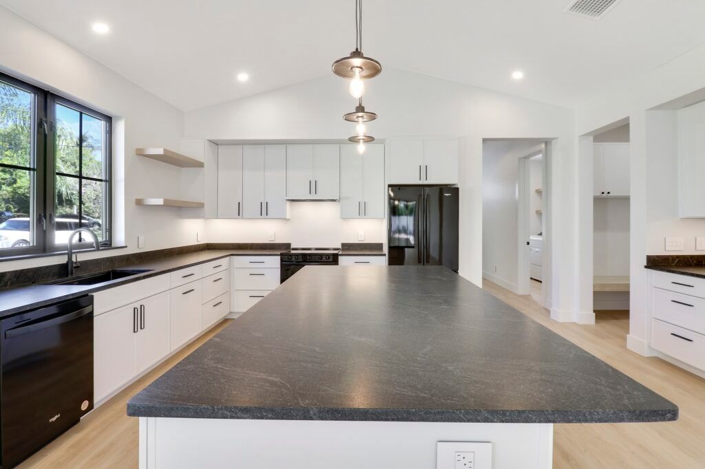 A kitchen with a large island and white cabinets