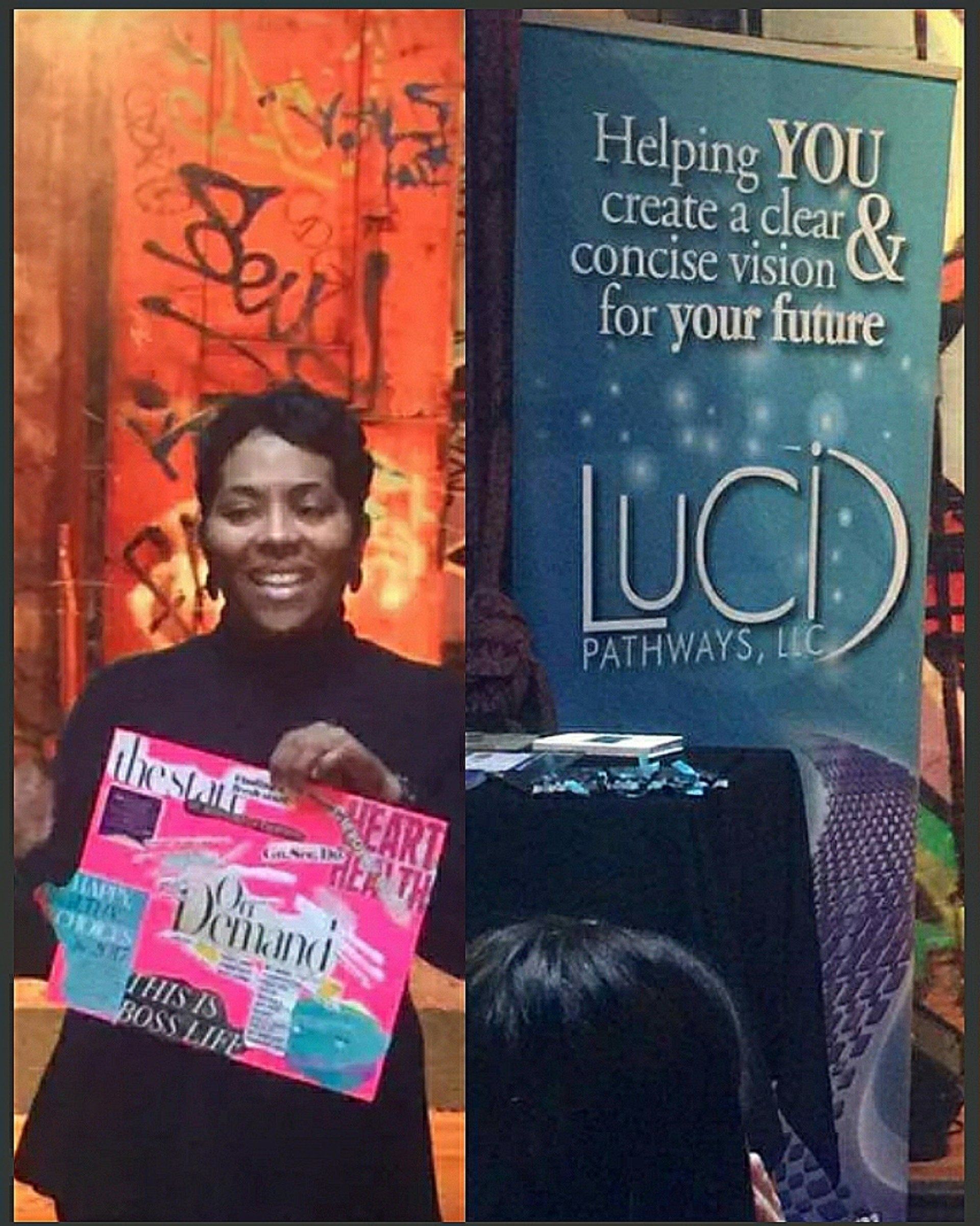 A woman holding a sign that says helping you create a clear & concise vision for your future