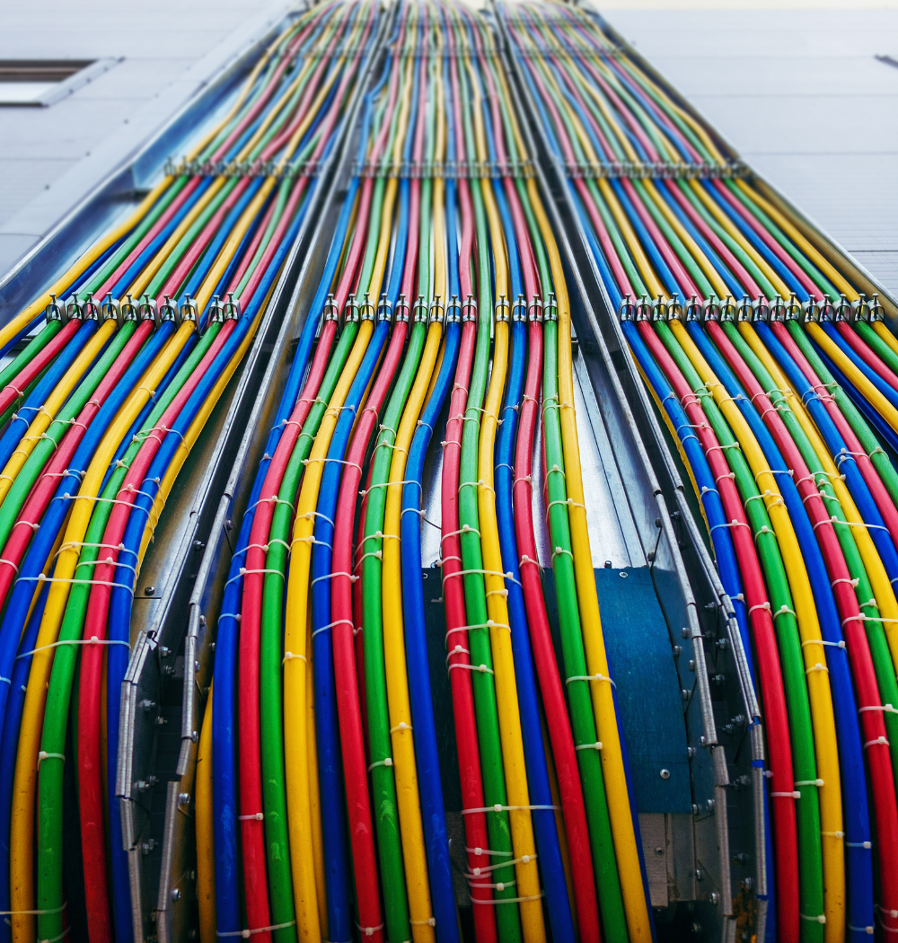 Colorful electrical cables routed along a building exterior.