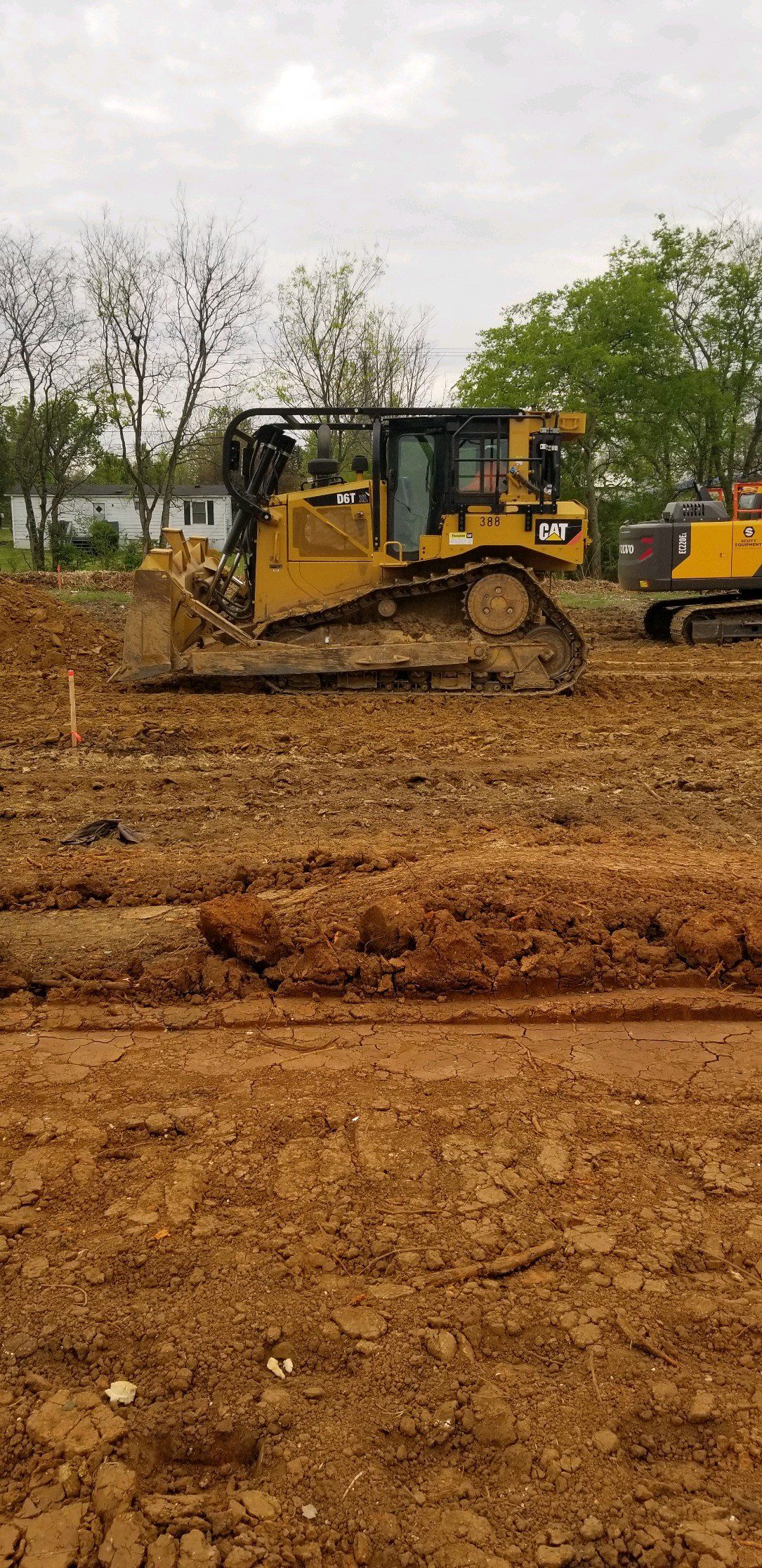 A bulldozer is moving dirt in a field.