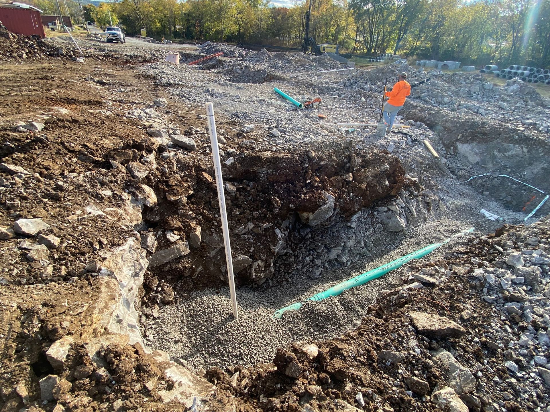 A man is digging a hole in the dirt in a construction site.