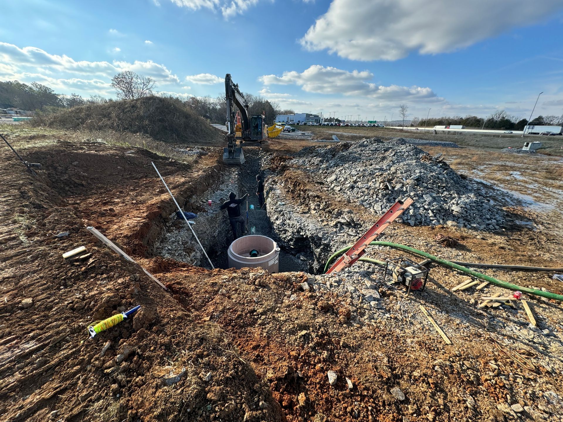 A man is digging a hole in the dirt in a construction site.
