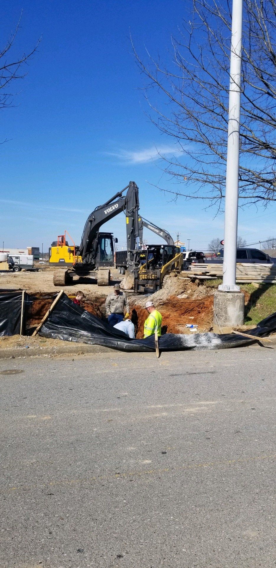 A construction site with a large excavator in the background.