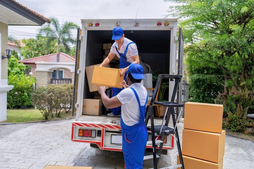 Two Men Are Loading Boxes Into a Moving Truck — TJ Removals and Storage in Wagga Wagga, NSW