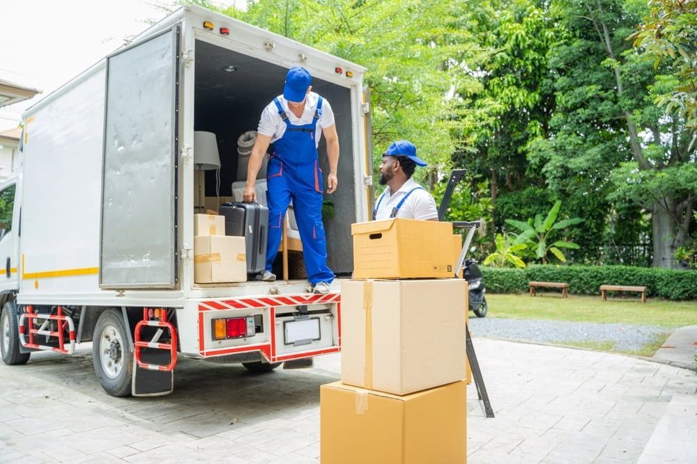 A Man is Loading Boxes Into a Moving Truck — TJ Removals and Storage in Junee, NSW