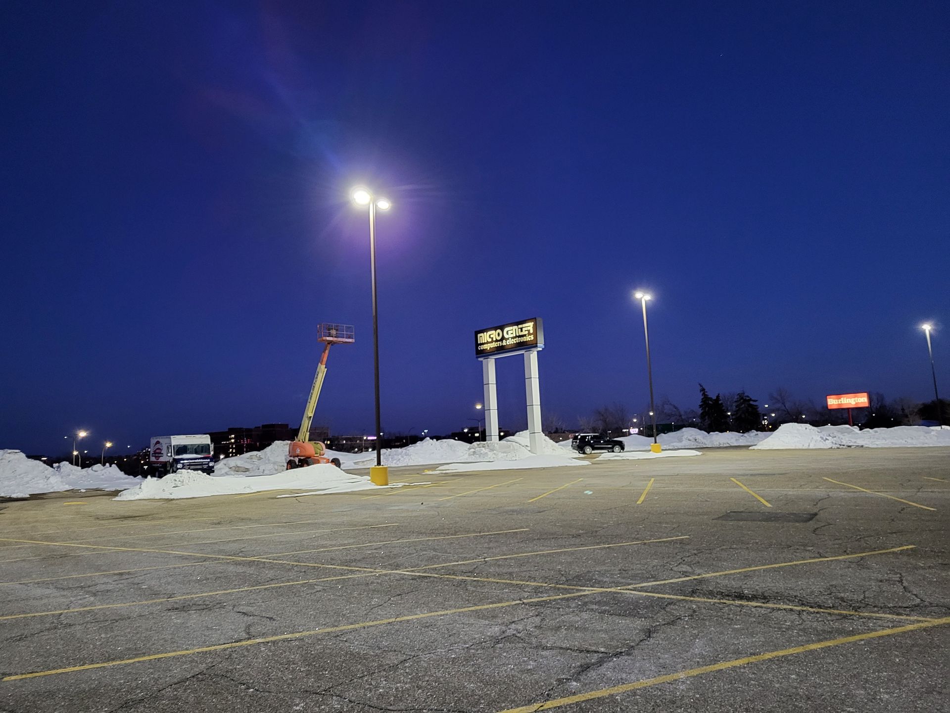 An empty parking lot at night with a sign that says ' abc ' on it