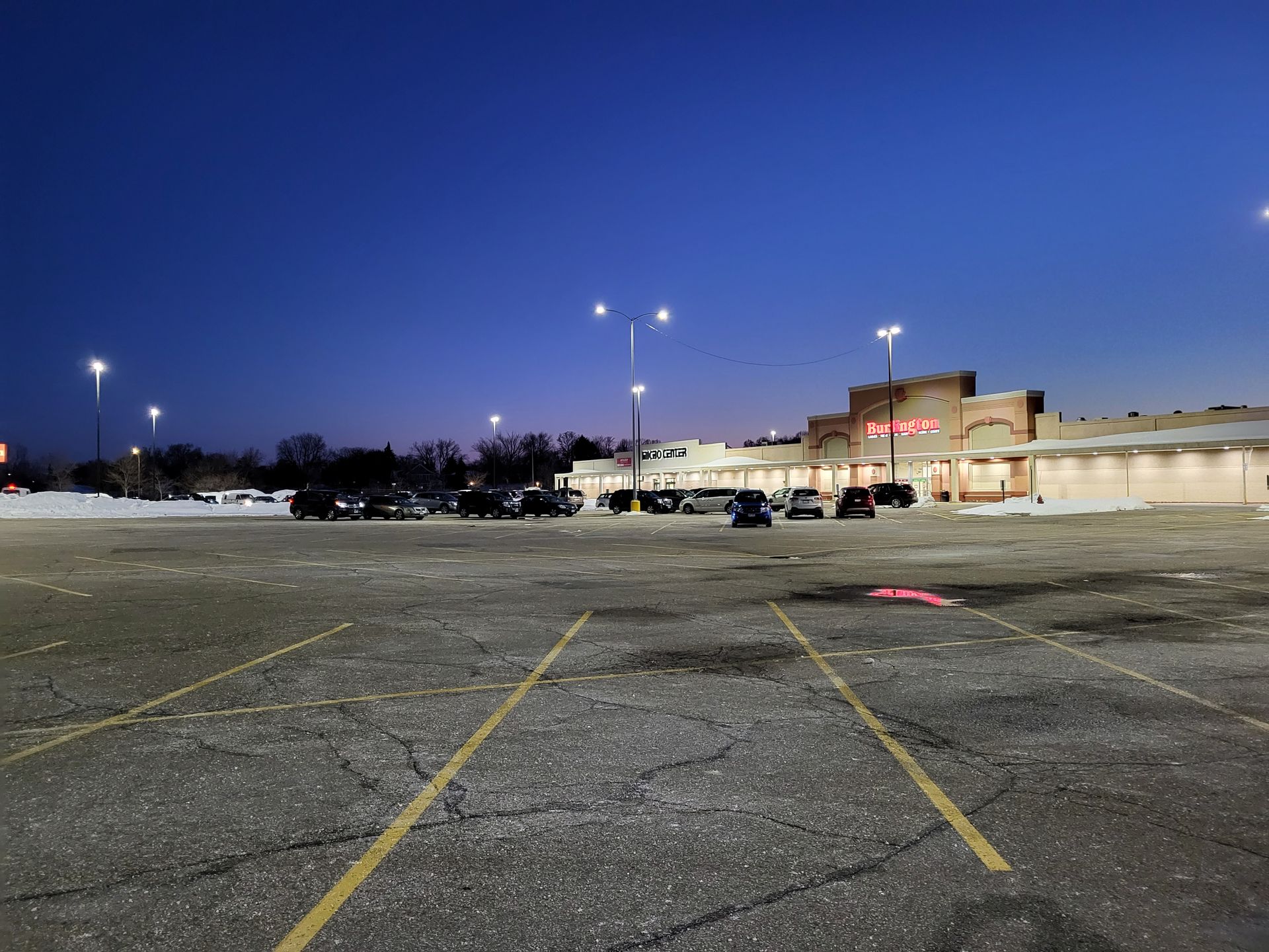 An empty parking lot in front of a store at night