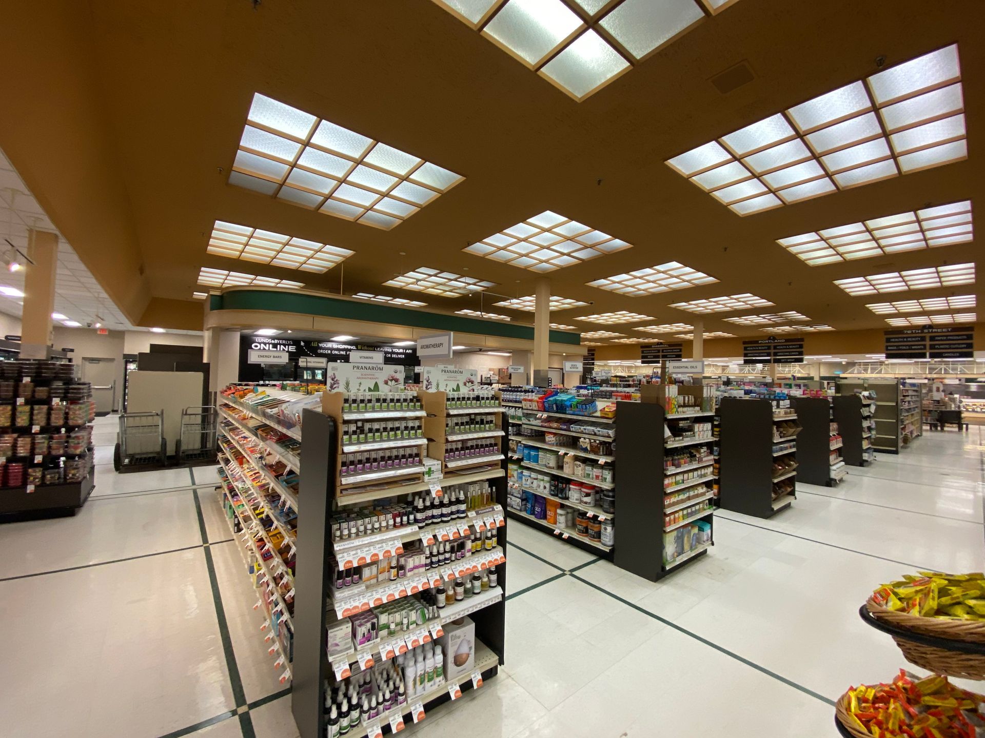 The inside of a grocery store with lots of shelves and lights.