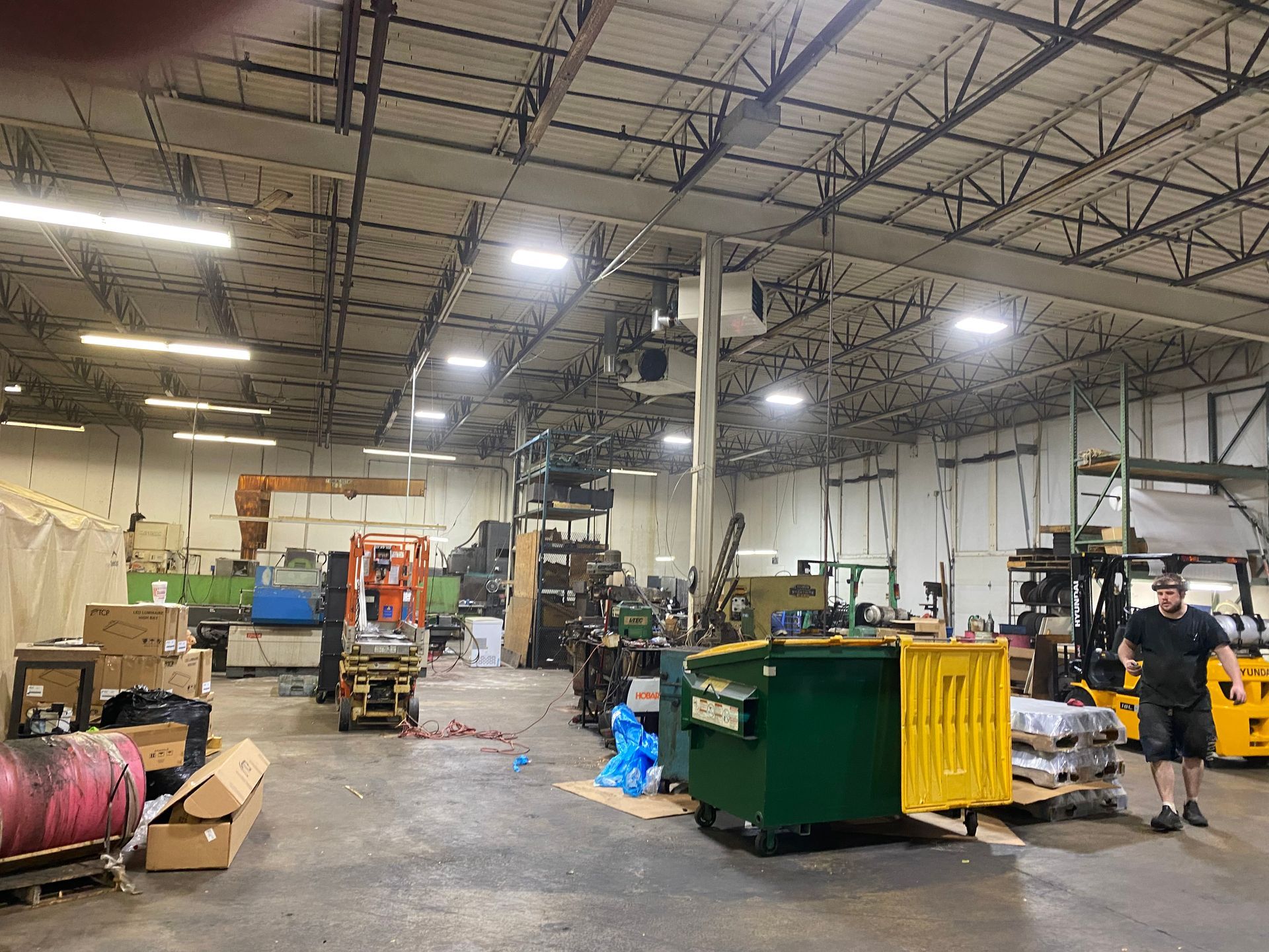 A man is standing in the middle of a large warehouse.