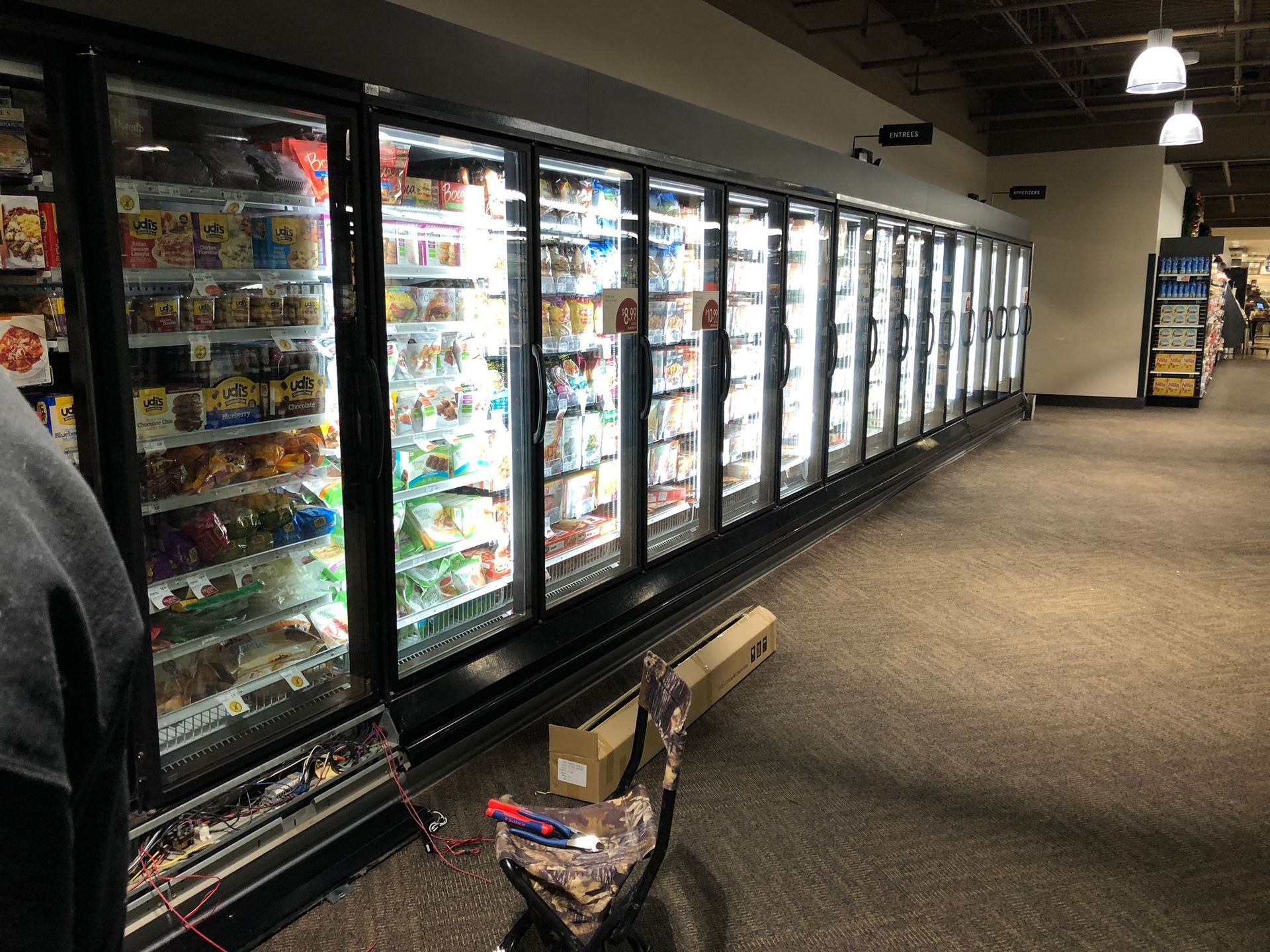 A row of refrigerators are lined up in a grocery store.