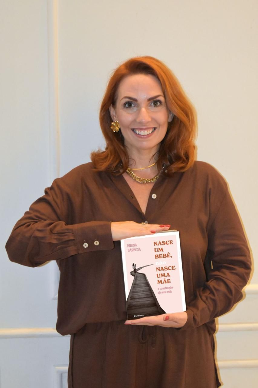 A woman in a brown shirt is holding a book