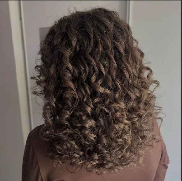 Une femme porte un chignon avec une fleur dans les cheveux.