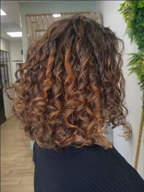 Une femme se fait coiffer dans un salon et a une tresse dans les cheveux.