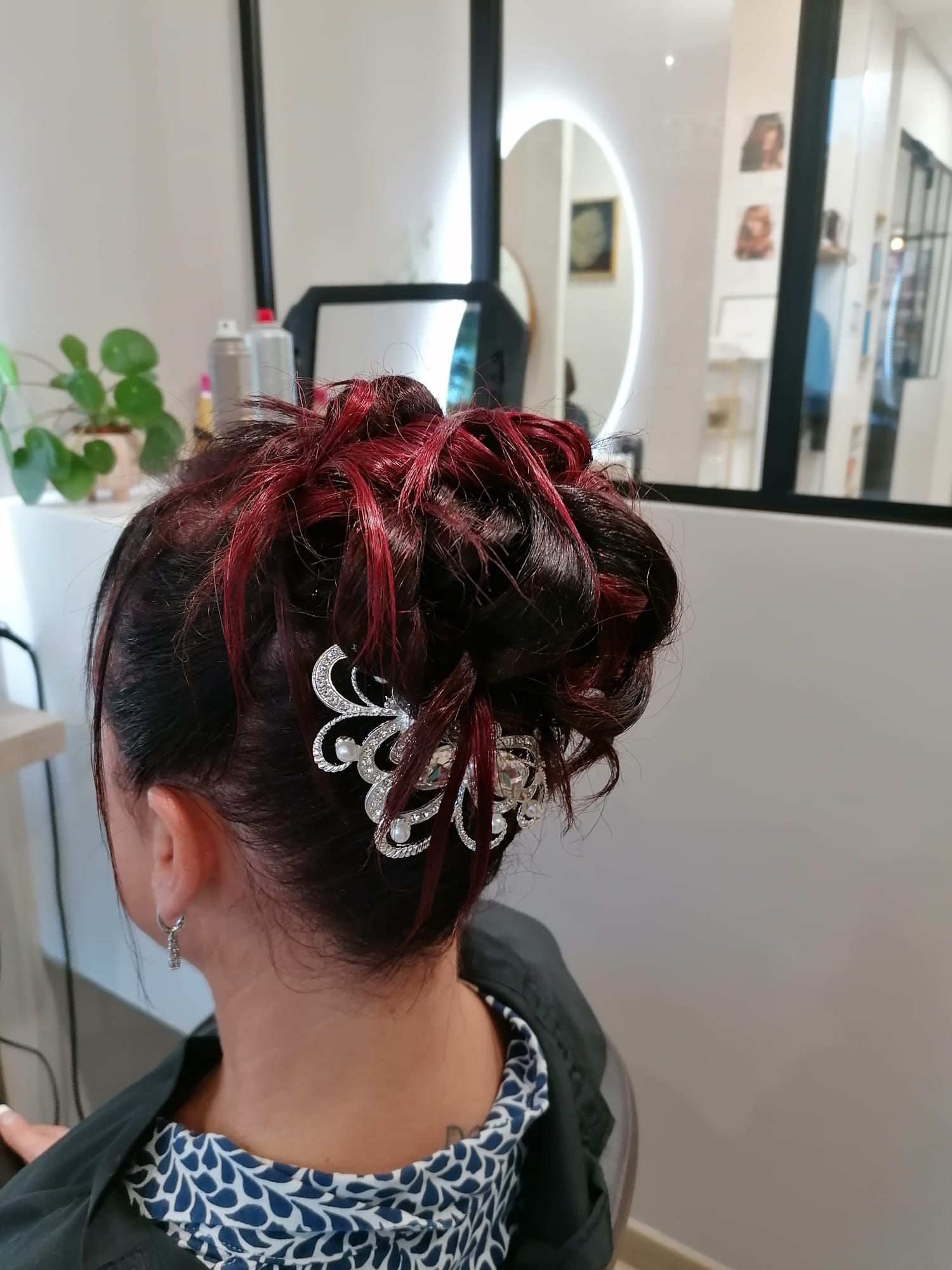 Une femme est assise sur une chaise avec ses cheveux en chignon.