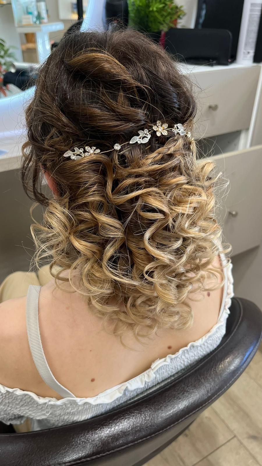 Une femme est assise sur une chaise avec ses cheveux en chignon.