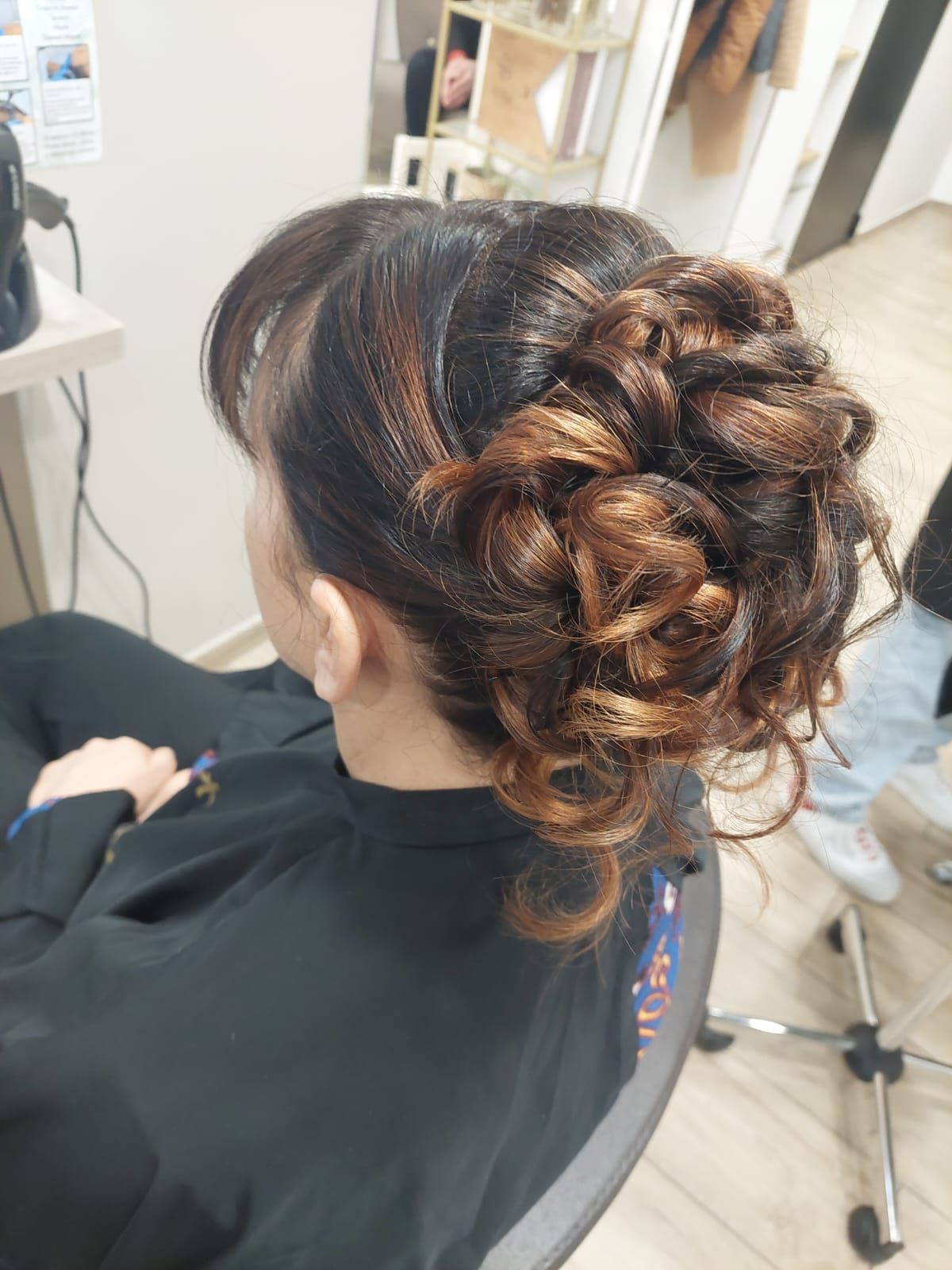 Une femme est assise sur une chaise avec ses cheveux en chignon.